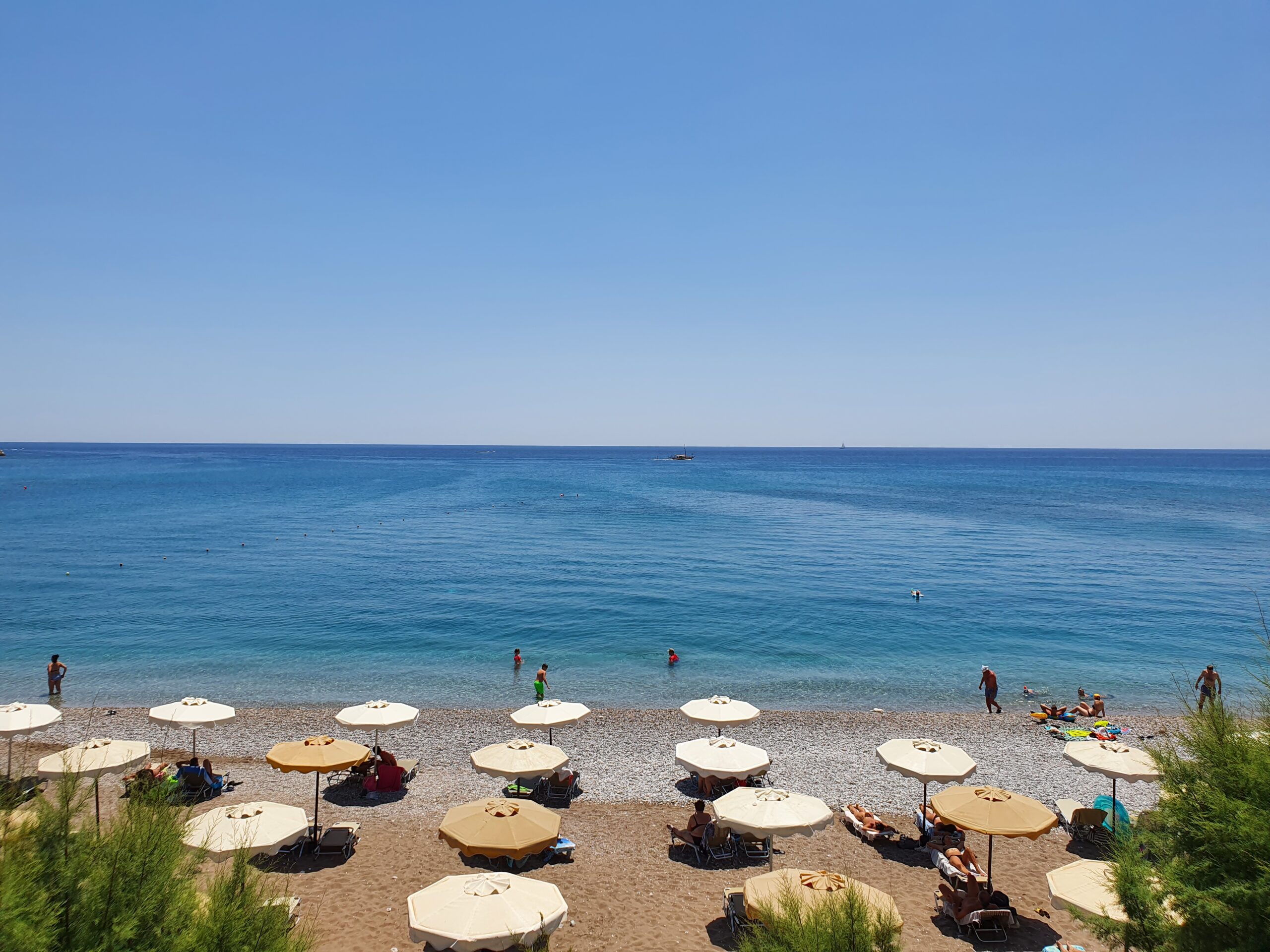 Een van de stranden op Rhodos. Een rustig strand, strandstoel en blauw water.