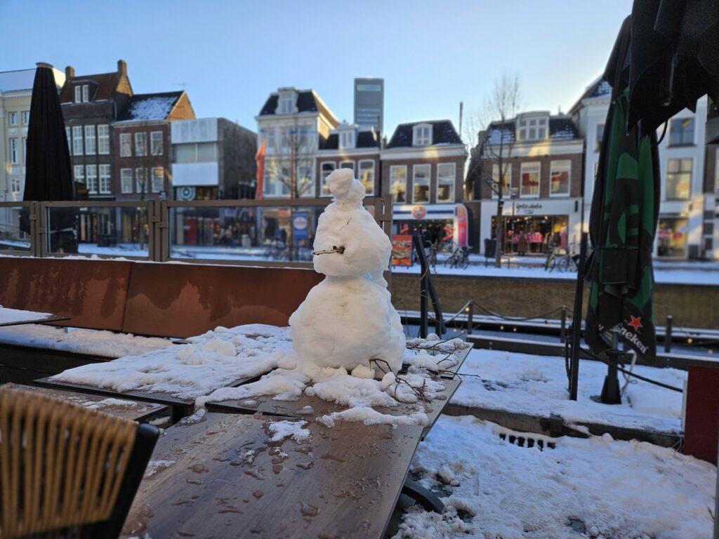 Sneeuwpop, op een terrastafel in winters Leeuwarden.