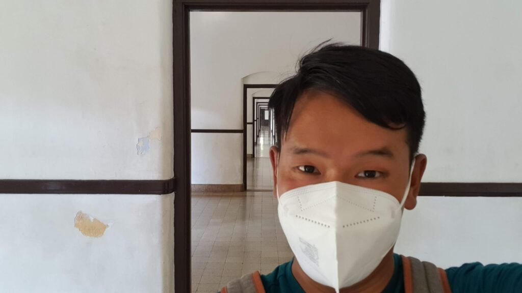 Eindeloze gangen van Lawang Sewu met een bezoeker op de voorgrond in Semarang.