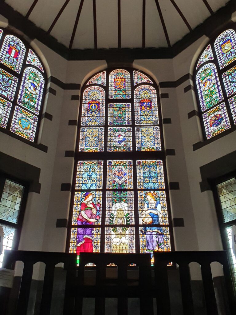 Glas-in-loodraam van Lawang Sewu met kleurrijke historische afbeeldingen.