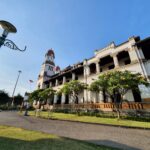 Vooraanzicht van Lawang Sewu met Indonesische vlag en koloniale torens in Semarang.