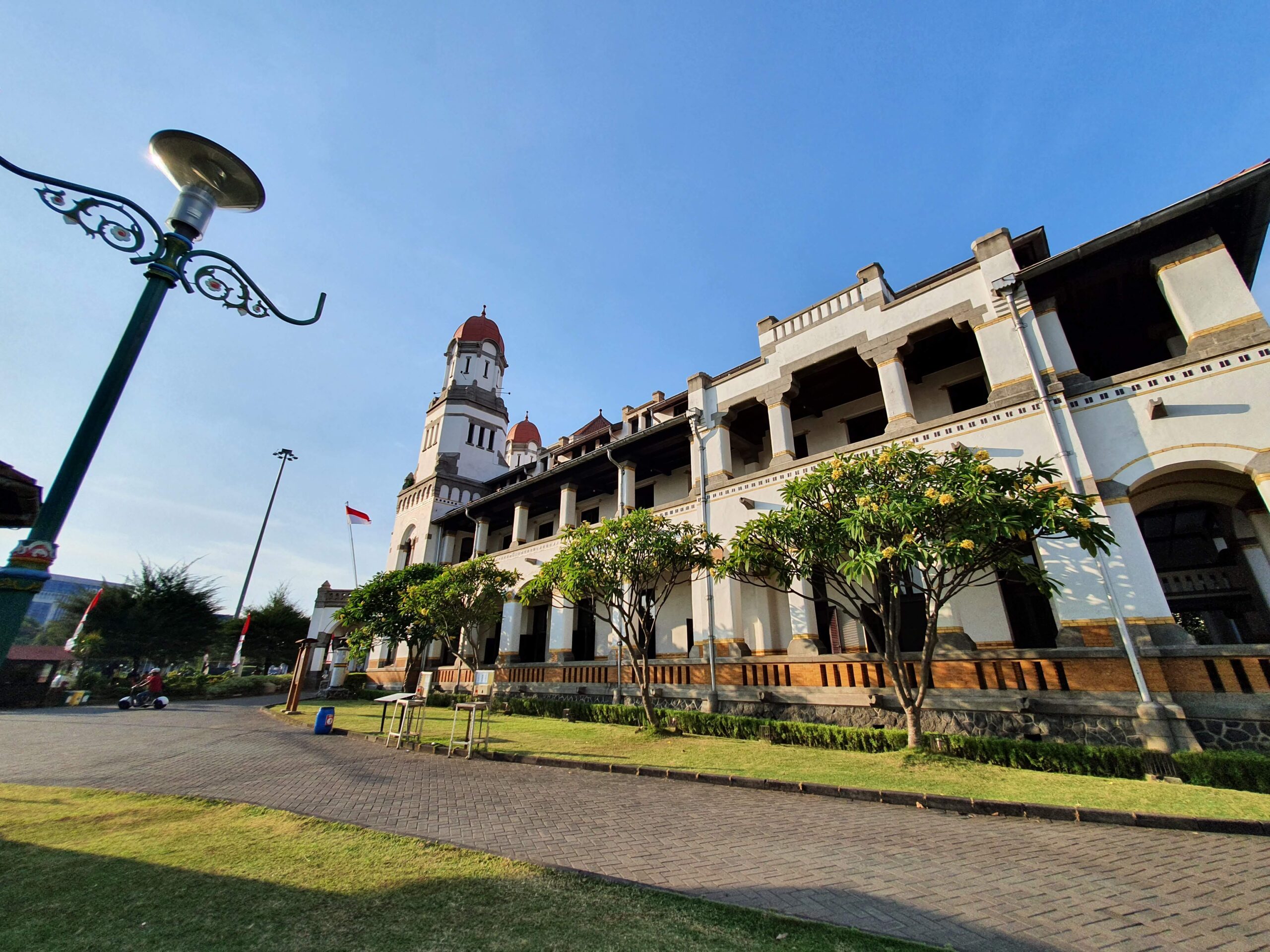 Vooraanzicht van Lawang Sewu met Indonesische vlag en koloniale torens in Semarang.