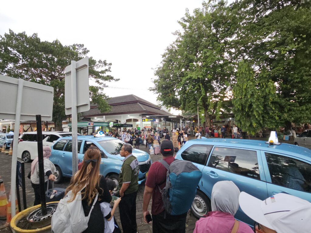 Reizigers en taxi's buiten station Surabaya na aankomst van de Argo Semeru uit Yogyakarta.