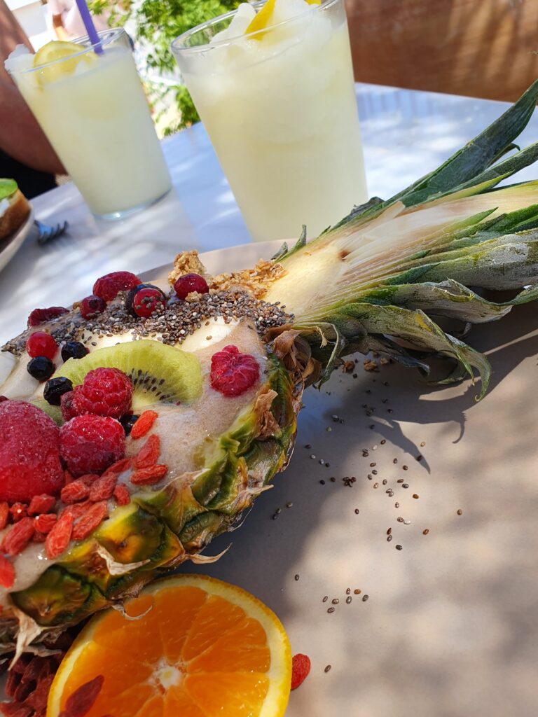 Gezonde lunch geserveerd in een halve ananas met verse limonade op een terras in Lindos.