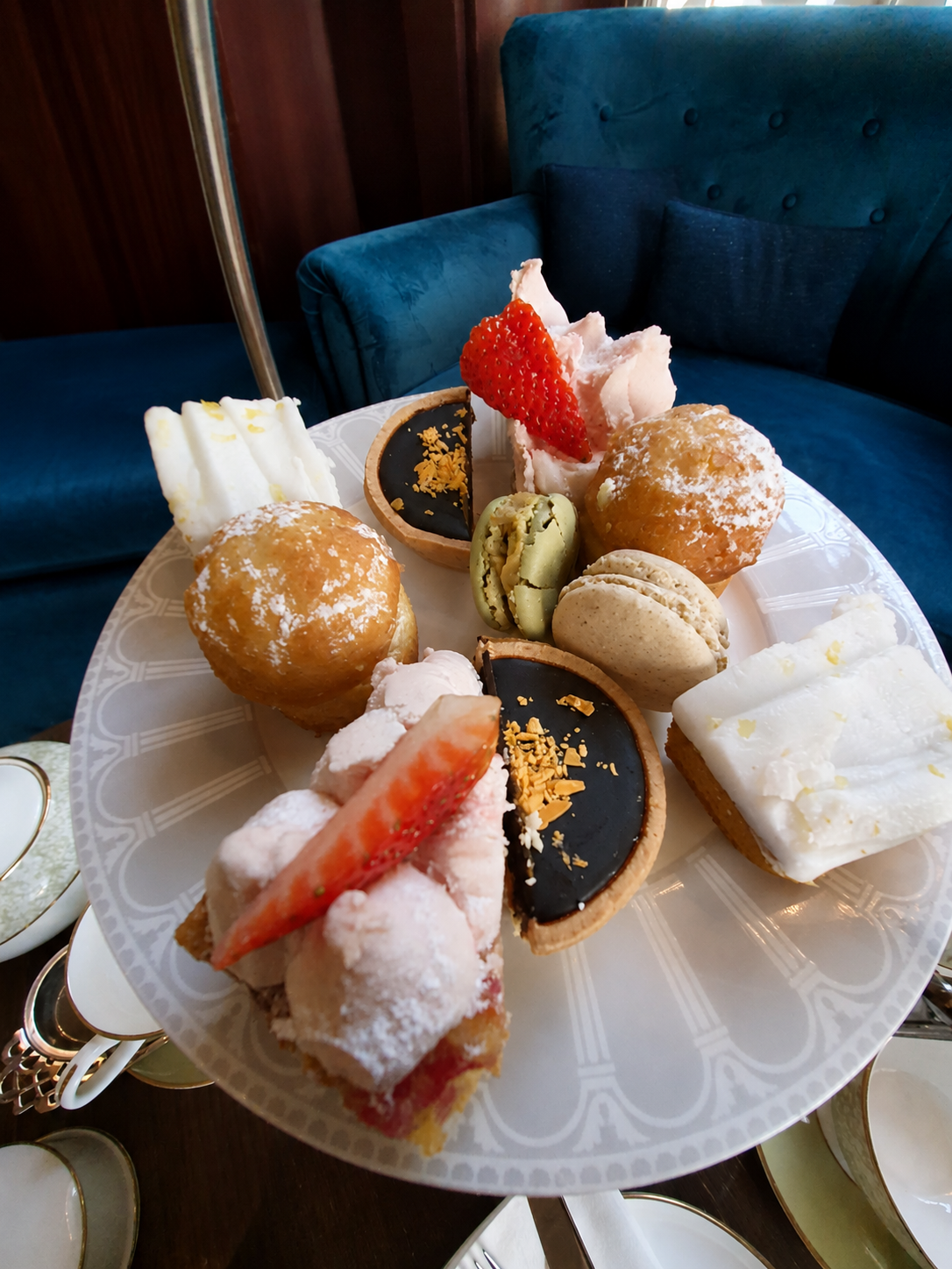 Een etagère vol kleurrijke taartjes, macarons en gebak tijdens een traditionele afternoon tea in Londen.