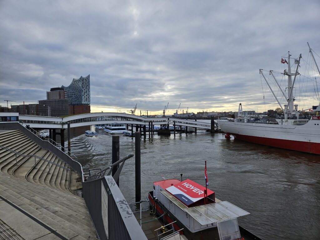 Uitzicht over de haven van Hamburg met de Elbphilharmonie, historische schepen en de rivier de Elbe.