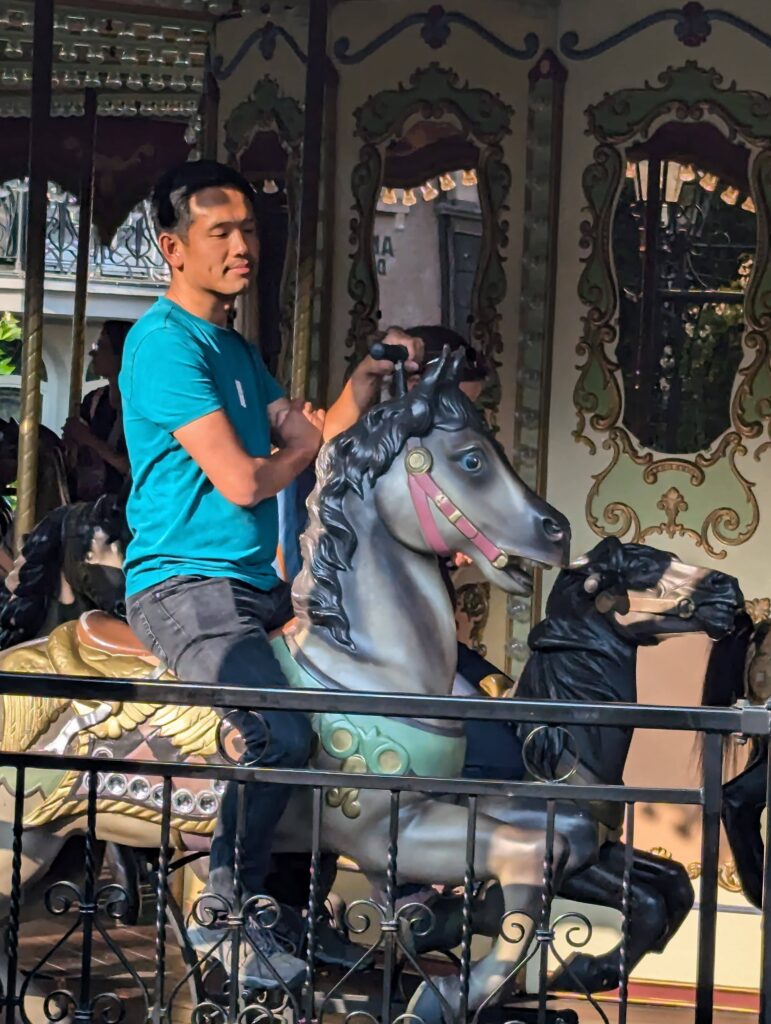 Zittend op een houten paard van de klassieke carrousel in Phantasialand.