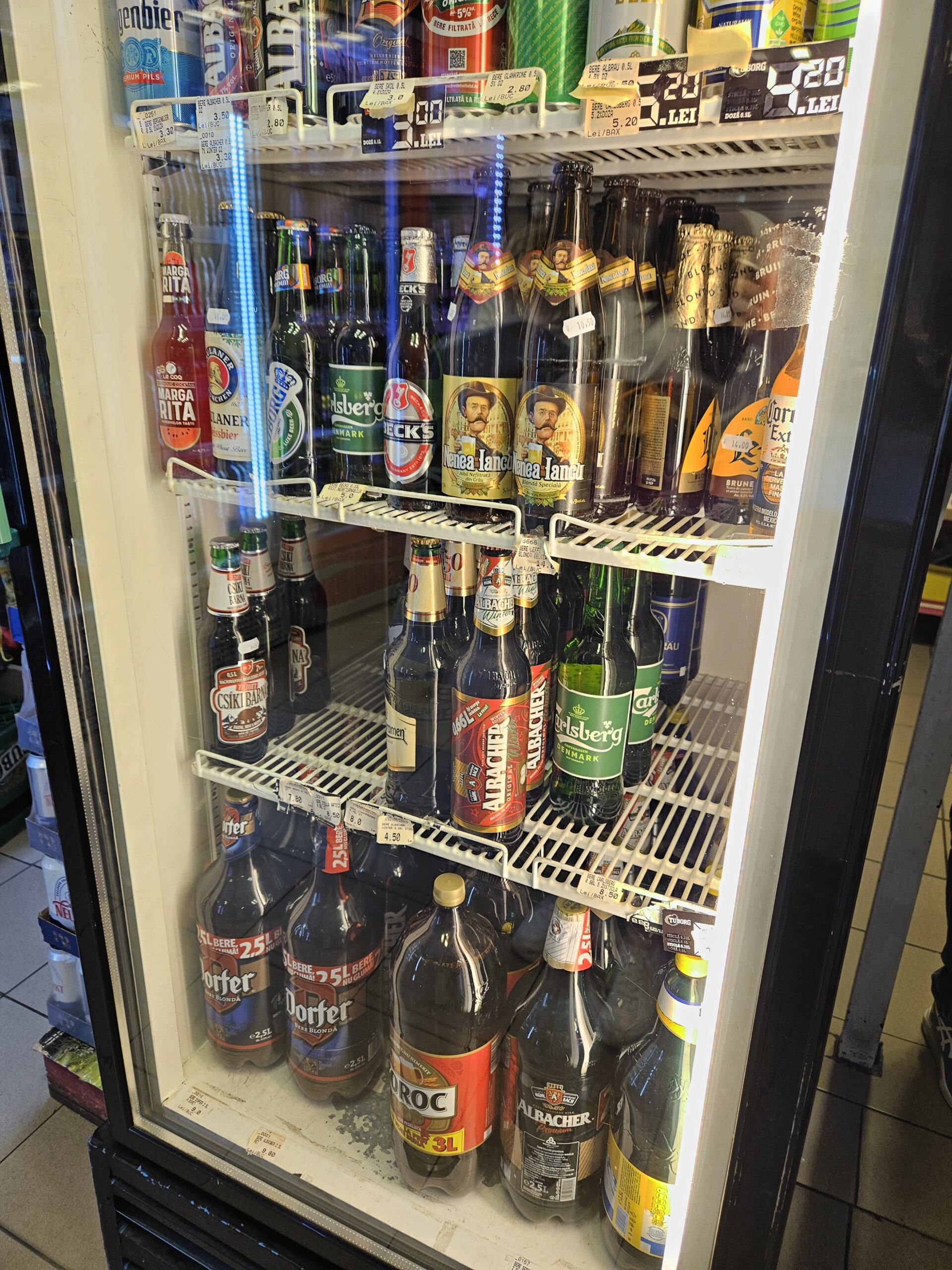 Koeling met bierflessen in verschillende formaten in een buurtwinkel in Boekarest.