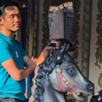 Bezoeker geniet ontspannen van een ritje op een klassieke carrousel in Phantasialand tijdens een zonnige dag.