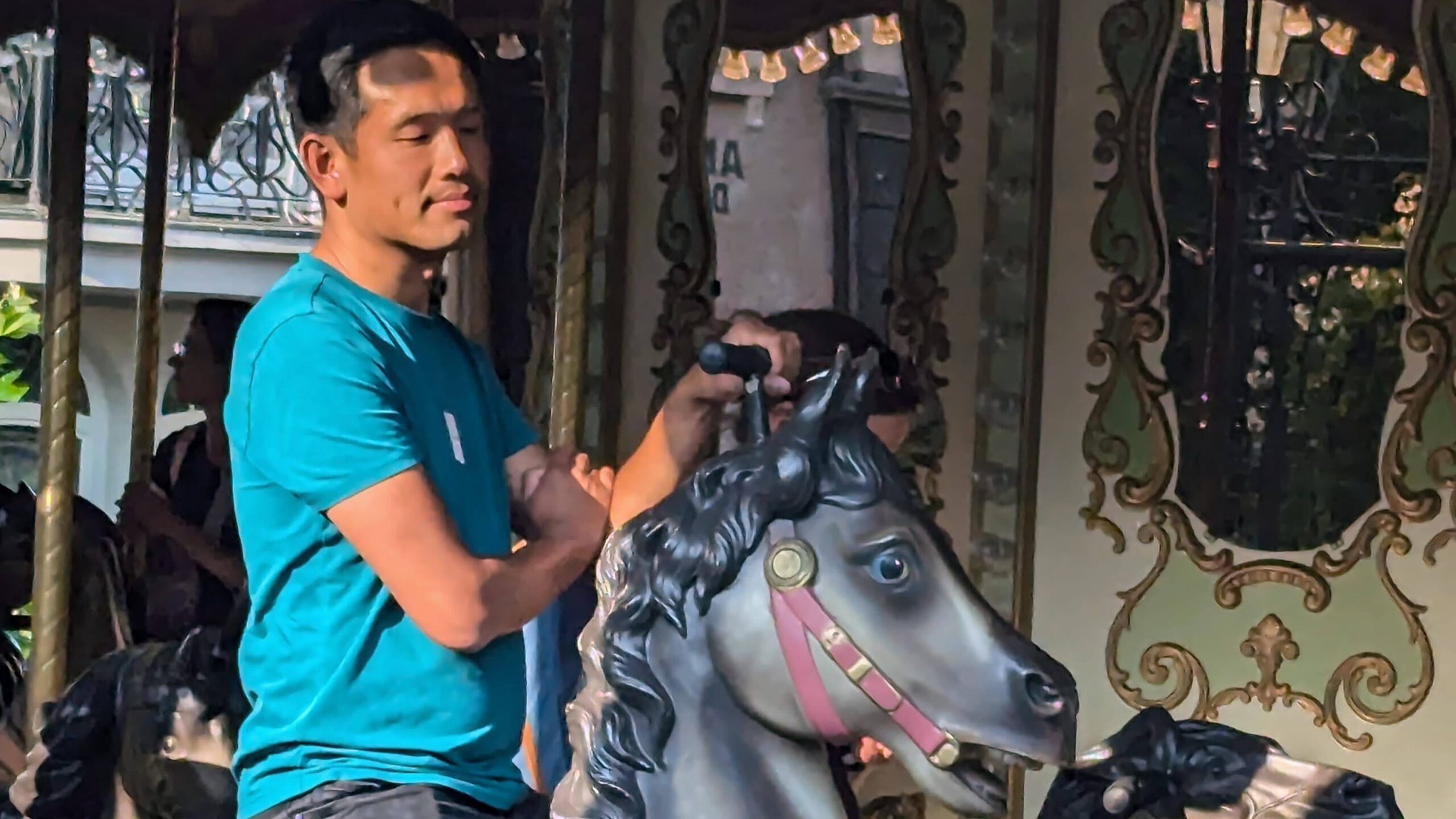 Bezoeker geniet ontspannen van een ritje op een klassieke carrousel in Phantasialand tijdens een zonnige dag.