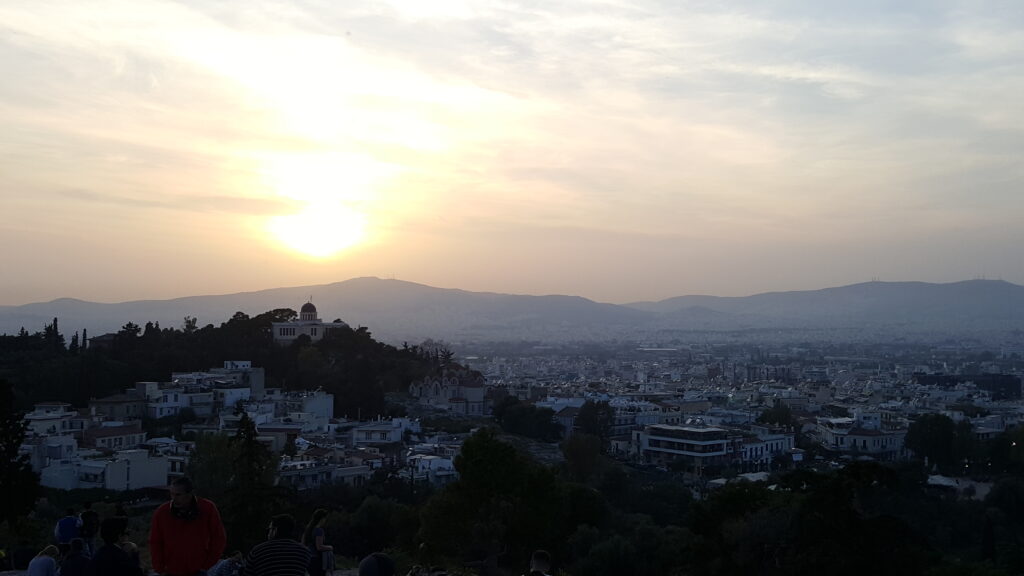 Uitzicht over Athene tijdens zonsondergang met de Lycabettusheuvel op de achtergrond.