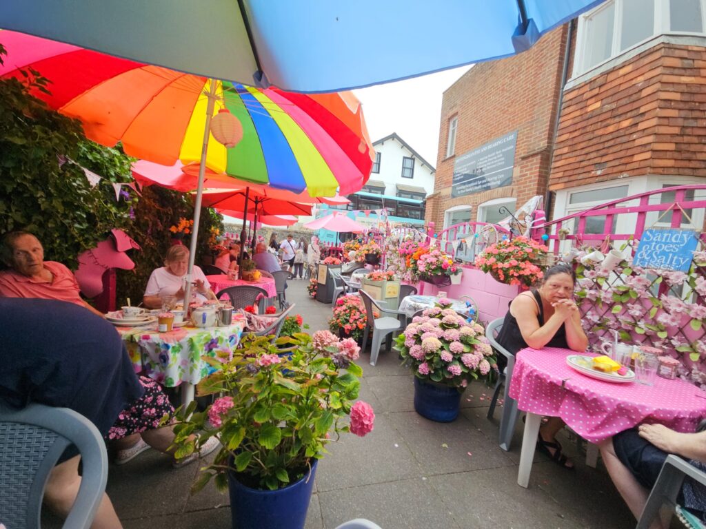 Kleurrijk terras van The Trellis Café met parasols en bloemen